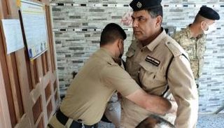 عنصر أمني أمام حاجز تفتيش استعداداً للمشاركة بالاقتراع الخاص