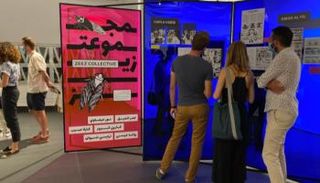 زوار المعرض يشاهدون أحد الأعمال المشاركة