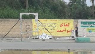 صبي يجمع لافتات مرشحين عقب انتهاء انتخابات سابقة في العراق - أرشيفية