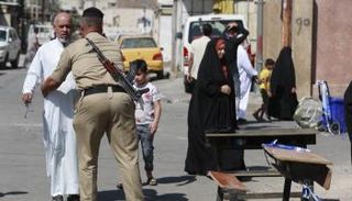 جندي عراقي يفتش أحد الناخبين أمام مركز اقتراع-  ا  ف ب