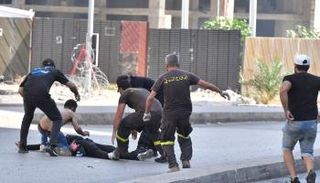 محاولة لإسعاف أحد الجرحى على الطريق في الطيونة