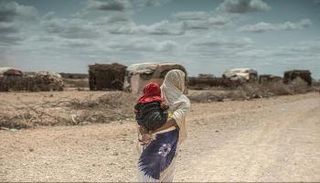 سيدة تحمل طفلها على ظهرها