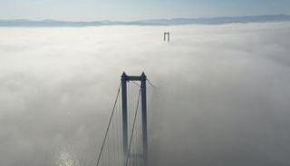 الضباب يغطي جسر "شهداء 15 يوليو" بالكامل