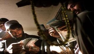 تجار أفغان يعدون الأموال في أسواق وسط كابول - رويترز