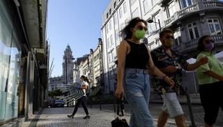 مارة يرتدون كمامة للوقاية من فيروس كورونا في لشبونة (أرشيفية)