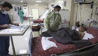 أطباء يطمئنون على صحة أحمد قاسم بأحد مستشفيات إدلب- أسوشيتد برس