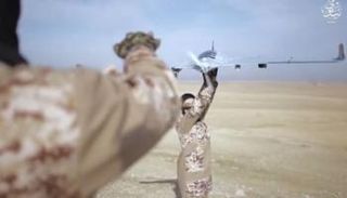 داعشي يحمل طائرة مسيرة