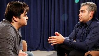 الصحفي الإيراني علي رضواني على يمين الصورة