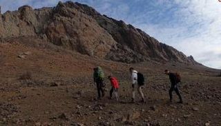 الطفل مع متسلقين آخرين في طريقهم للجبل