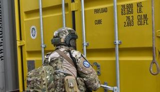 أحد عناصر إيريني لحظة تفتيشه السفينه المشتبه بها