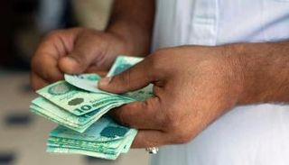 ليبي يحصي عددًا من الأوراق النقدية. (أرشيفية)