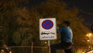 تركيب إحدى اللوحات المرورية بعد سرقة أخرى بإيران