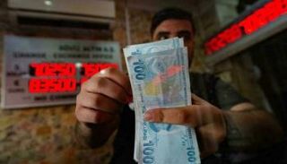 موظف بمكتب صرافة يعد أوراقا من الليرة التركية