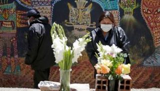 امرأة تقف أمام قبر أحد ذويها في بوليفيا