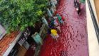 بالصور.. فيضان بـ"لون الدم" يغرق قرية إندونيسية