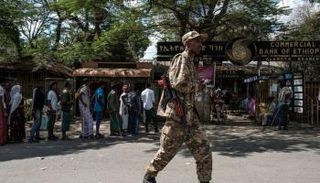 جندي يمر بجانب أشخاص خارج أحد البنوك في ألاماتا الإثيوبية - الفرنسية