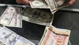 موظف بأحد مصارف ليبيا يحصي أوراقًا من فئة الـ20 دينارا (أرشيفية)