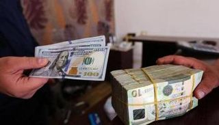 موظف بأحد مصارف ليبيا يحصي أوراقًا من فئة الـ10 دينارات - أرشيفية