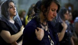 مسيحيون يؤدون قداسا في إحدى كنائس بغداد