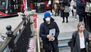 شاب يرتدي كمامة للوقاية من فيروس كورونا في بريطانيا