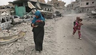 امرأة موصلية برفقة أطفالها عند المدينة القديمة - إرشيفية