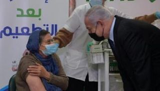 نتنياهو يتحدث مع سيدة تتلقى تطعيم كورونا