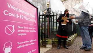شخصان أمام مركز للتلقيح ضد كورونا في لندن