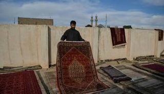 تاجر يعمل على تجفيف سجاداته بتعريضها لاشعة الشمس في مدينة هيرات الأفغانية