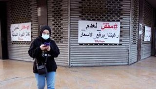 مركز تسوق مغلق وعلى أبوابه لافتة 