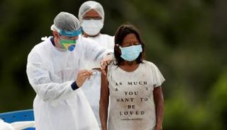 طبيب يحقن برازيلية من السكان الأصليين بلقاح كورونا