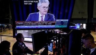 متداولون يعملون وهم يتابعون مؤتمر صحفي سابق لرئيس المركزي الأمريكي - رويترز