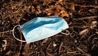 قناع وجه ملقى على الأرض مهددا بنقل فيروس كورونا