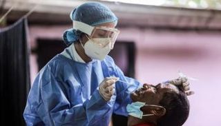 عاملة صحية تأخذ مسحة من رجل في فنزويلا