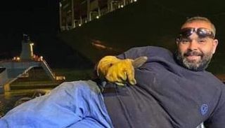 الصورة الأشهر لأحد العمال المشاركين في تعويم السفينة