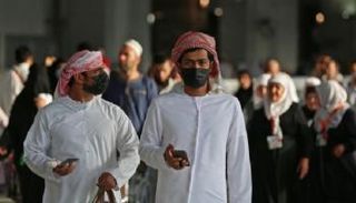رجلان يرتديان كمامتين للوقاية من فيروس كورونا في السعودية (أرشيفية)