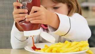 طفلة تضع الكاتشب الذي ارتفع سعره بفضل كورونا