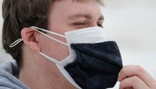 رجل يرتدي كمامتين للوقاية من فيروس كورونا