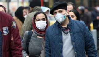 شابان يرتديان كمامتين للوقاية من فيروس كورونا في إيران (أرشيفية)