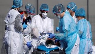 طاقم طبي يتابع حالة مريض بكورونا