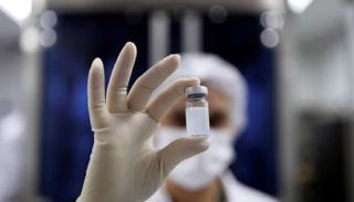 عاملة صحية تحمل قارورة لقاح