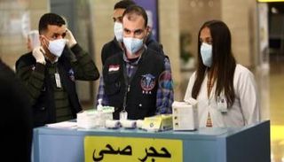 طاقم طبي أمام بوابة دخول حجر صحي