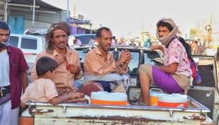 يمنيون في طريقهم للعمل في شوارع عدن