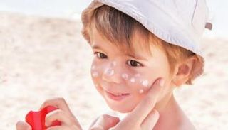 وضع الكريم الواقي من الشمس على وجه طفل - أرشيفية