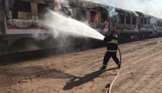 عامل إطفاء  يحاول إخماد حرائق القطار
