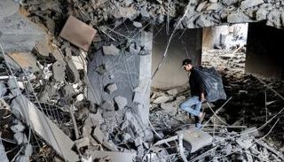 فلسطيني وسط ركام إحدى المباني المتضررة من القصف الإسرائيلي- أ.ف.ب