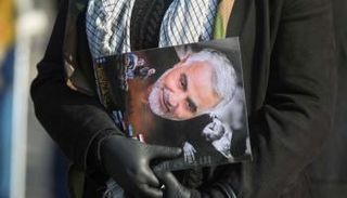 شخص يحمل صورة سليماني