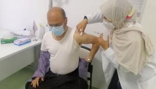 مواطن يتلقى جرعة من لقاح كورونا بأحد مستشفيات ليبيا