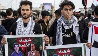 متظاهرون يرفعون صور صحفيين اغتيلوا مطلع العام الماضي