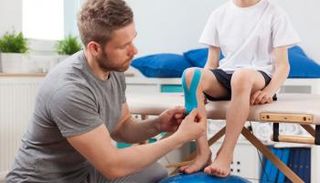 طبيب يكشف على طفل مصاب