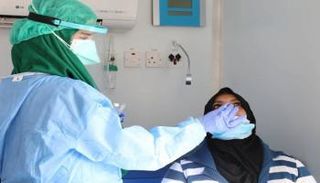 طبيبة تفحص إحدى المواطنات بمستشفى في ليبيا